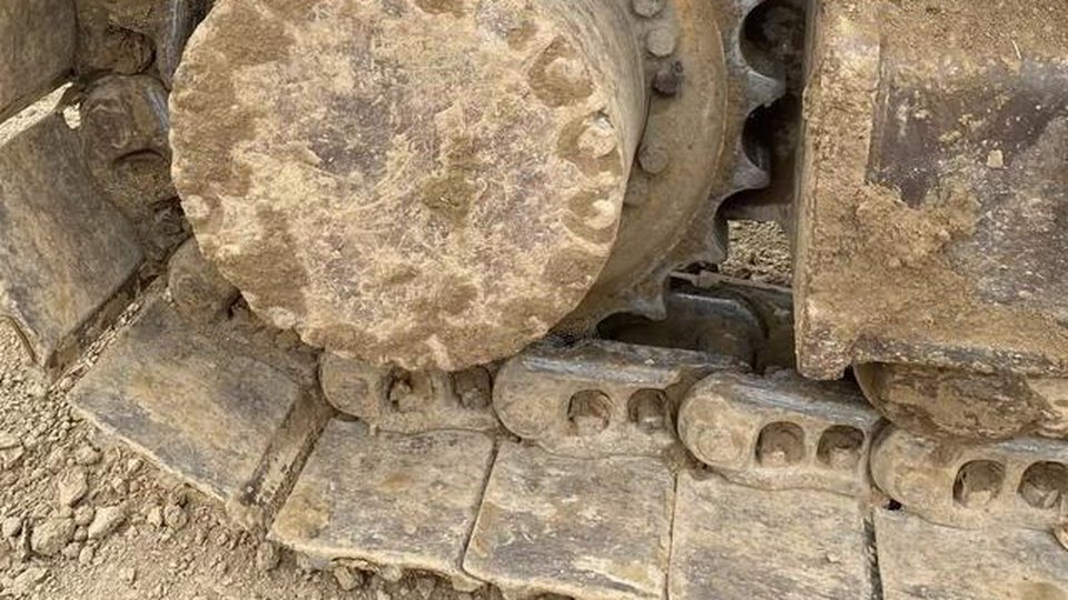 Close-up of an excavator final drive, sprocket and track links